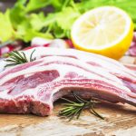 Raw lamb chops with spices and herbs close-up on wooden background